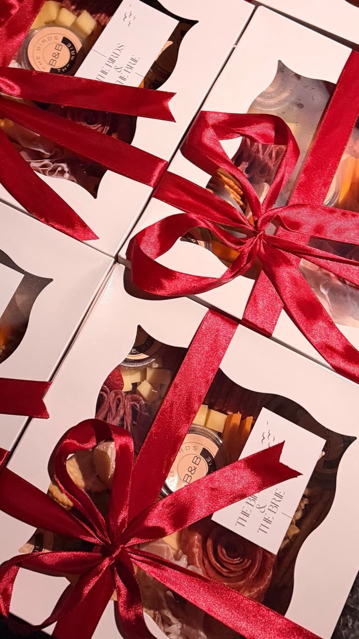 Premium charcuterie gift boxes wrapped with burgundy ribbon