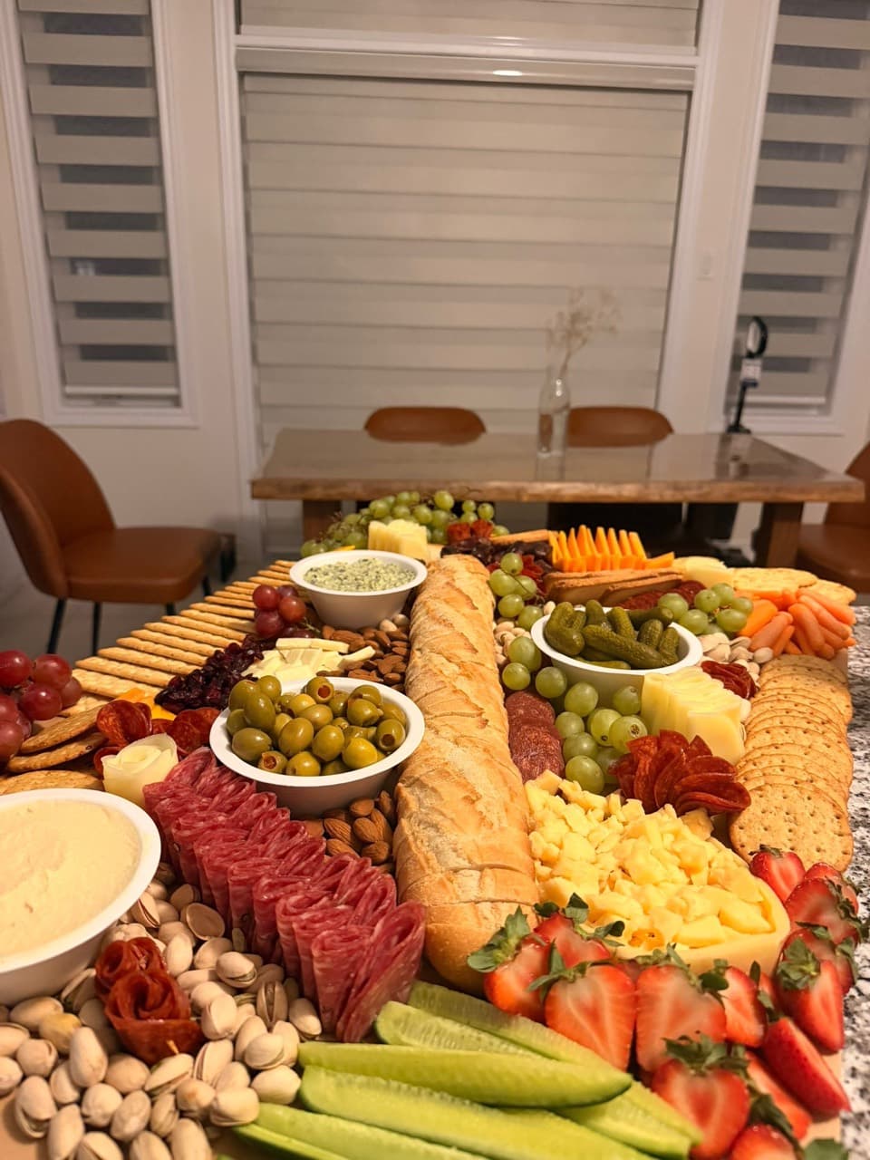 Indoor grazing table with baguette, charcuterie and fresh produce